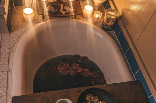 New Moon Ritual Bath with candles, crystals, ayurvedic sweets, hot tea, and midnight dahlias.