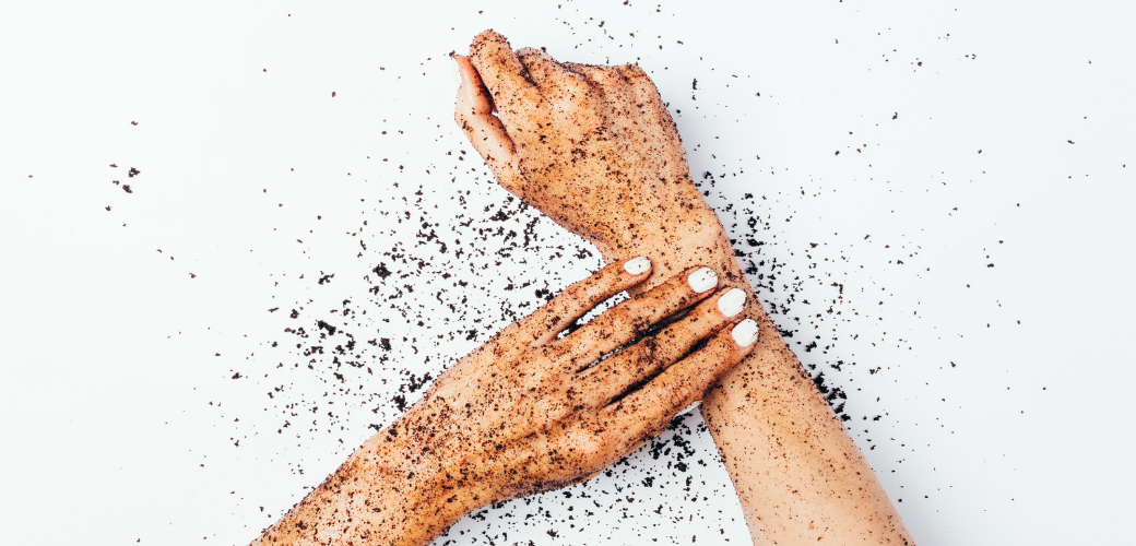 A person exfoliating their arms with an exfoliant