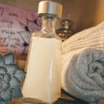 a bottle of homemade non-toxic laundry detergent next to clean towels