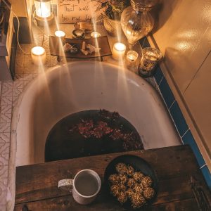 New Moon Ritual Bath with candles, crystals, ayurvedic sweets, hot tea, and midnight dahlias.