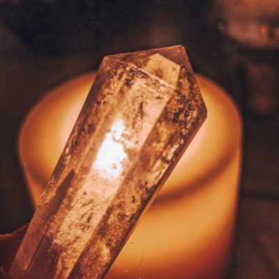 Clear Quartz Crystal in the light of a candle for a New Moon ritual bath