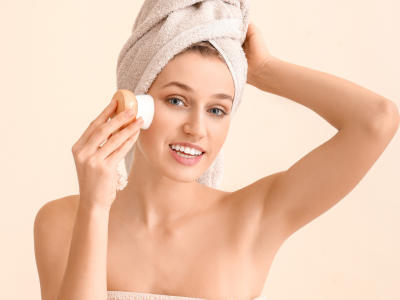 A woman using a dry brush to exfoliate her skin physically