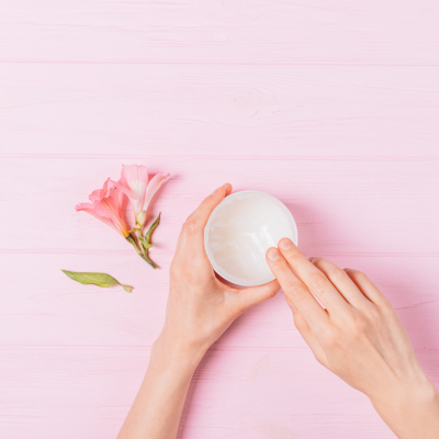 Hands applying beef tallow for skin care